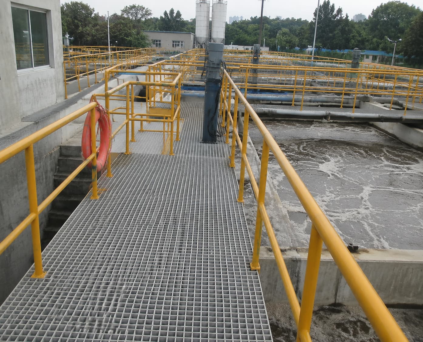 FRP grating installed on wastewater treatment plant platforms and maintenance walkways in wet industrial environments FRP grating installed on wastewater treatment plant platforms and maintenance walkways in wet industrial environments